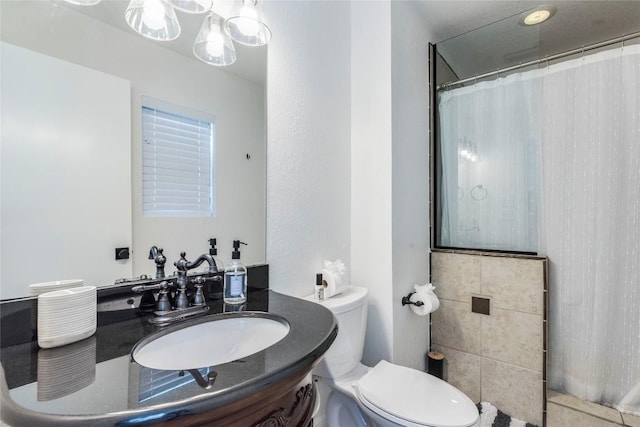 bathroom with curtained shower, vanity, and toilet