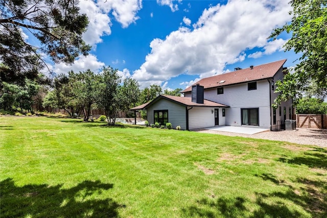 rear view of property with fence, cooling unit, a lawn, and a patio