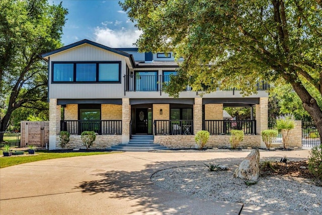 13113 Mansfield Dr, Austin, TX 78732 - view of front of home featuring a porch, a balcony, and stone siding