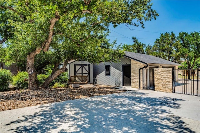 13113 Mansfield Dr, Austin, TX 78732 - view of front of property with stone siding, a shed, and concrete driveway