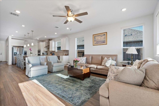 living area featuring visible vents, wood finished floors, and recessed lighting