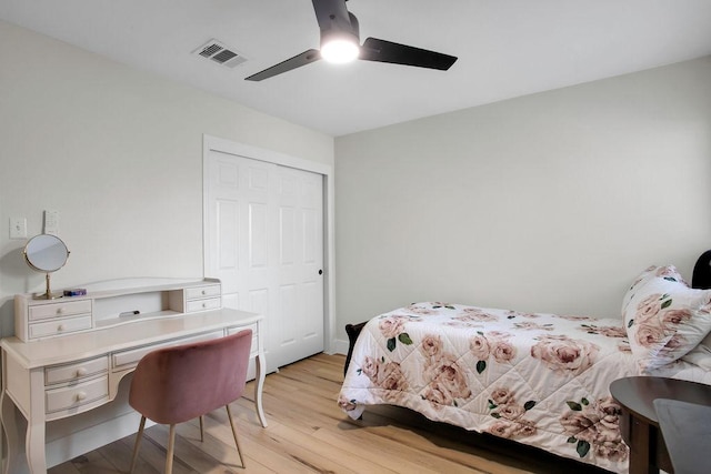 bedroom featuring light wood-style floors, a closet, visible vents, and ceiling fan