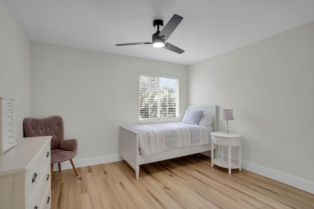 bedroom featuring a ceiling fan, light wood-type flooring, and baseboards