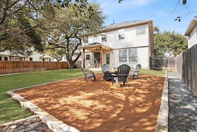 rear view of property with a fire pit, a yard, a patio area, and a fenced backyard