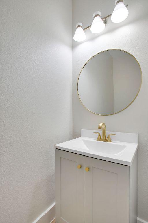 bathroom with a textured wall and vanity