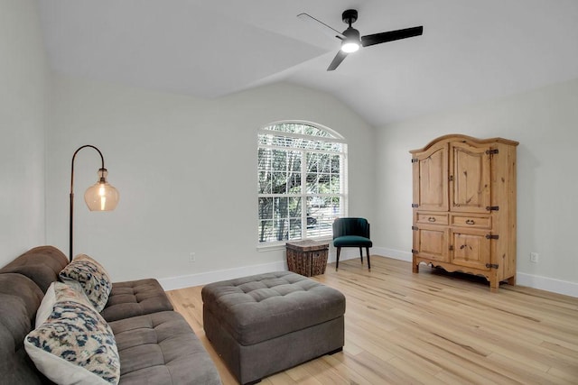 living area featuring lofted ceiling, a ceiling fan, light wood-style flooring, and baseboards