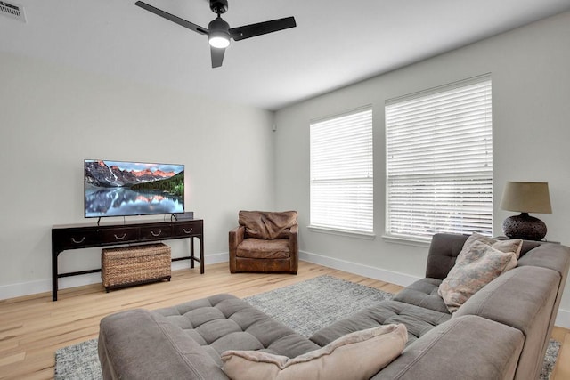 living room featuring wood finished floors, visible vents, and baseboards