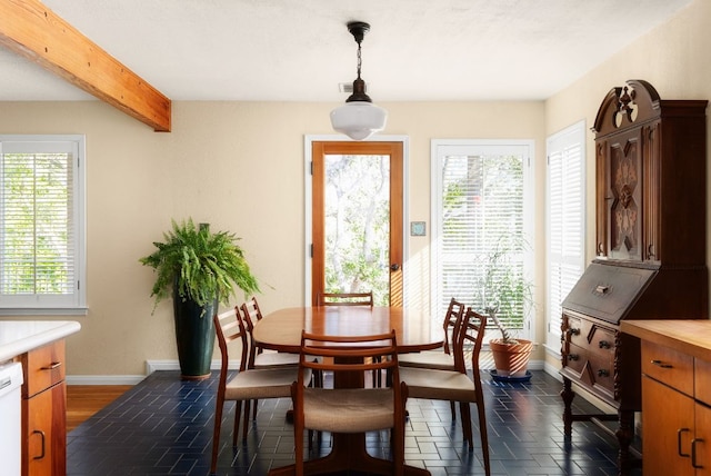 dining room with beamed ceiling and baseboards