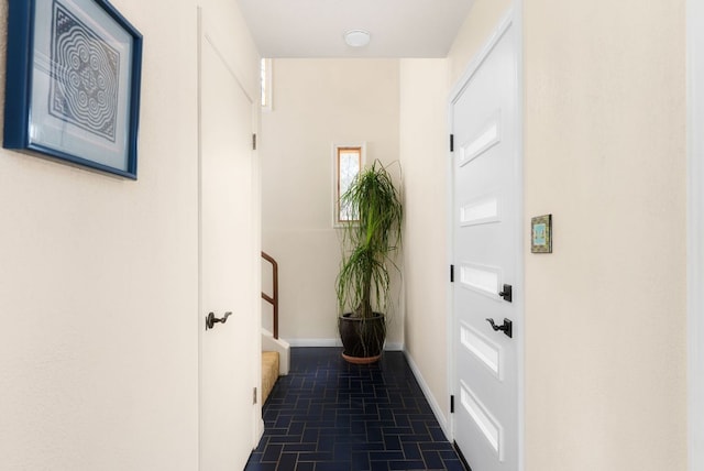 entryway with brick floor, stairway, and baseboards