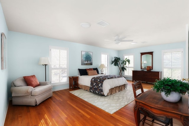 bedroom with visible vents, ceiling fan, and wood finished floors