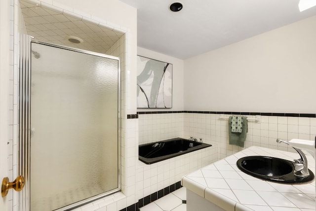 full bath featuring tile walls, a stall shower, a sink, a bath, and tile patterned floors