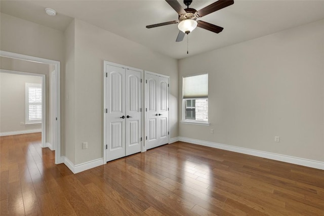 948 Hudson Ln, New Braunfels, TX 78130 - unfurnished bedroom featuring multiple closets, wood finished floors, and a ceiling fan