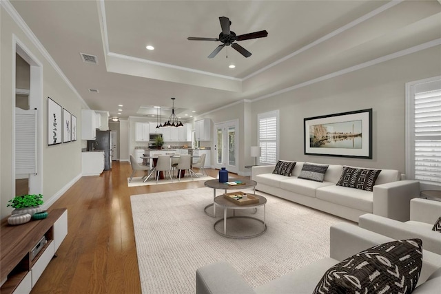 948 Hudson Ln, New Braunfels, TX 78130 - living area with a raised ceiling, wood finished floors, ornamental molding, recessed lighting, and a chandelier