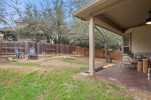 view of yard featuring an outdoor fire pit, a fenced backyard, a ceiling fan, and a patio