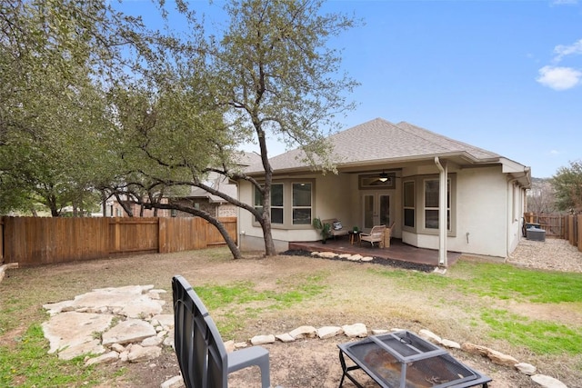 rear view of house featuring a patio, french doors, a fenced backyard, and stucco siding