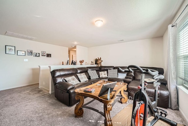 home theater featuring visible vents, baseboards, light colored carpet, and a textured ceiling