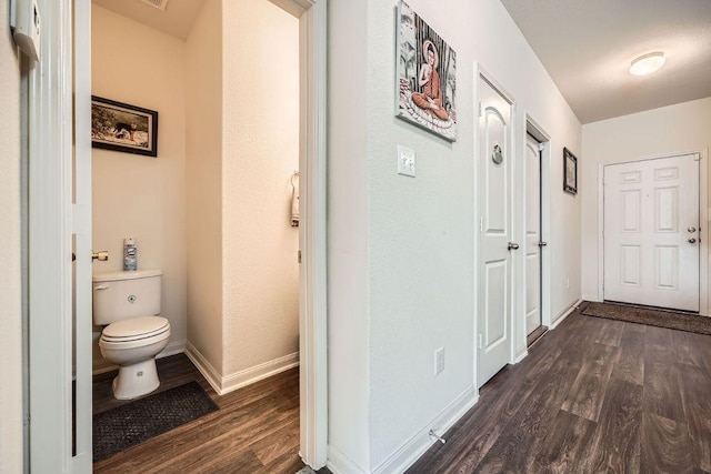 hall with dark wood-type flooring and baseboards