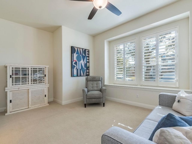 living area featuring carpet floors, a ceiling fan, and baseboards