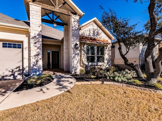 view of front of property with an attached garage, a shingled roof, stone siding, stucco siding, and a chimney