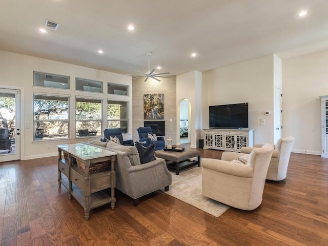 living room with a large fireplace, dark wood-style flooring, recessed lighting, and a healthy amount of sunlight