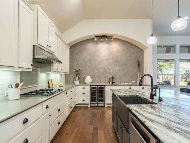 kitchen featuring appliances with stainless steel finishes, wine cooler, white cabinetry, and under cabinet range hood