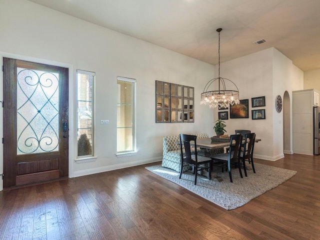 dining space with visible vents, dark wood finished floors, a notable chandelier, and baseboards