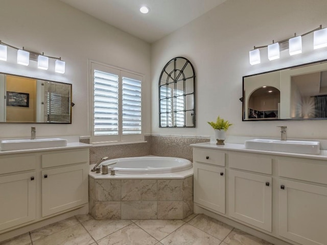 full bathroom featuring a garden tub, two vanities, and a sink