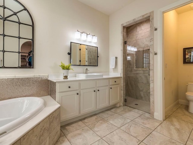 bathroom with a stall shower, a garden tub, vanity, and toilet