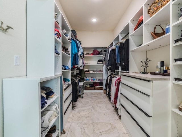 walk in closet with marble finish floor