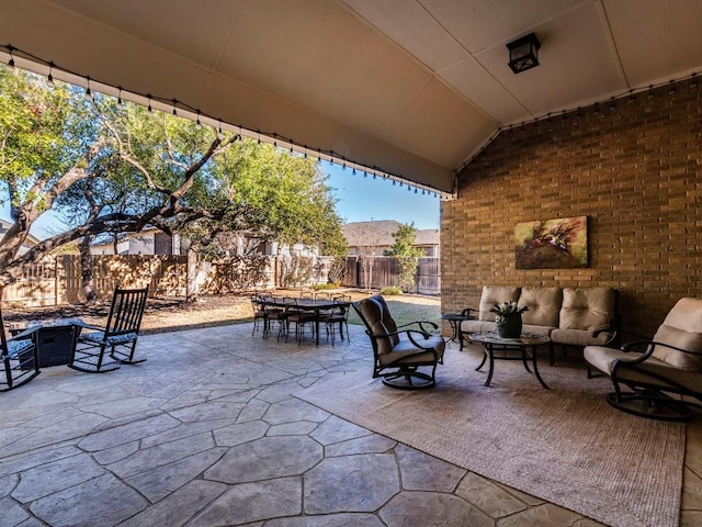 view of patio / terrace with outdoor dining space, a fenced backyard, and an outdoor living space