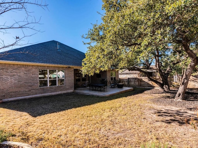 back of house with a patio area, fence, brick siding, and roof with shingles