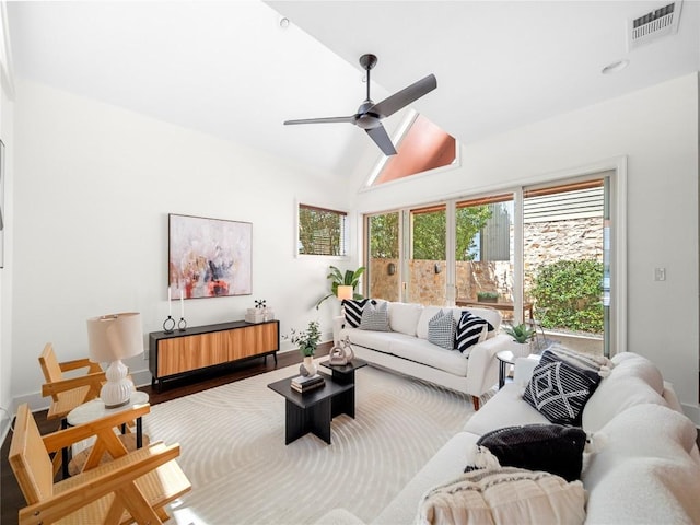 living area with a ceiling fan, lofted ceiling, visible vents, and wood finished floors