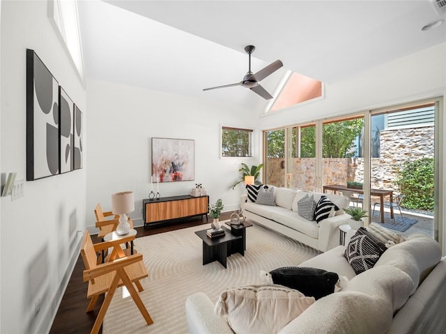 living room featuring a ceiling fan, high vaulted ceiling, baseboards, and wood finished floors