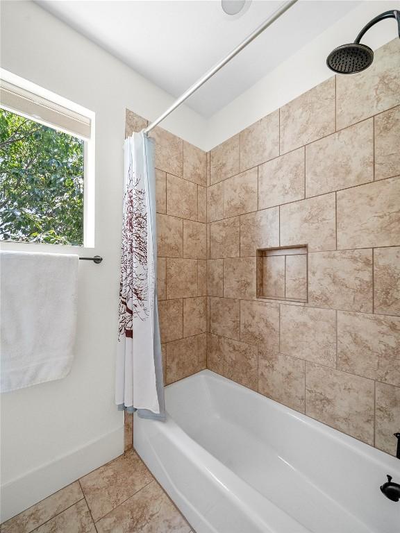 full bath with tile patterned flooring, baseboards, and shower / bath combo with shower curtain