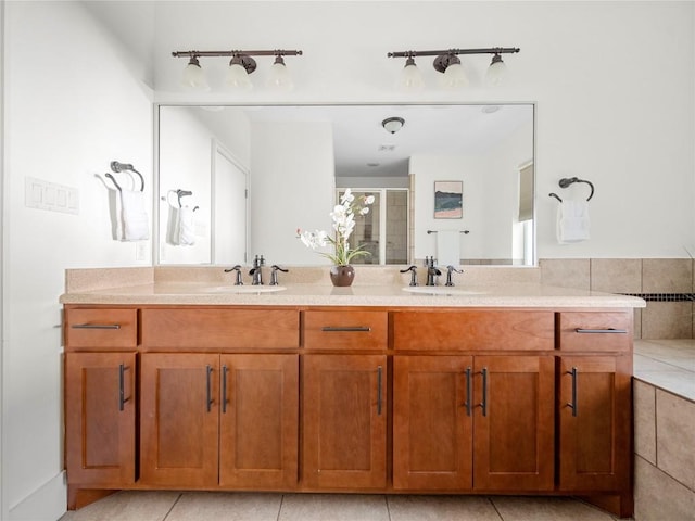 full bathroom with double vanity, tile patterned floors, a sink, and a shower stall