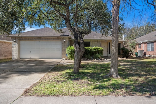 ranch-style home featuring brick siding, concrete driveway, an attached garage, central air condition unit, and a front yard