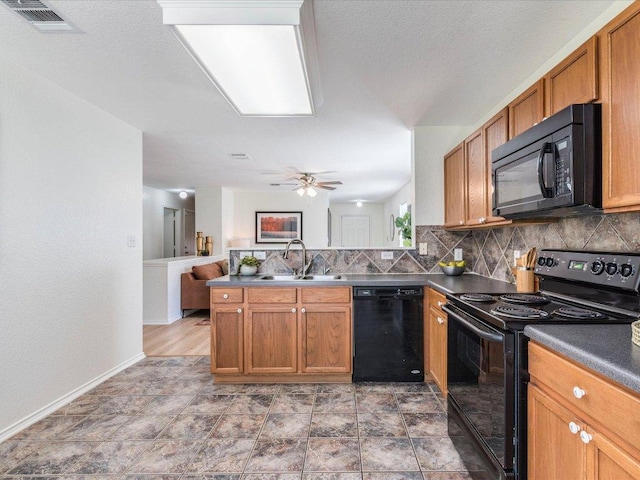 171 Beech Dr, Kyle, TX 78640 - kitchen with black appliances, a sink, decorative backsplash, dark countertops, and a peninsula