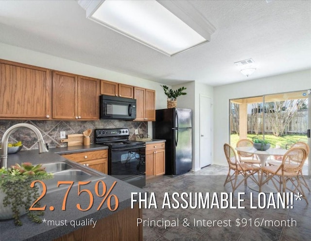 171 Beech Dr, Kyle, TX 78640 - kitchen with black appliances, tasteful backsplash, brown cabinets, dark countertops, and baseboards