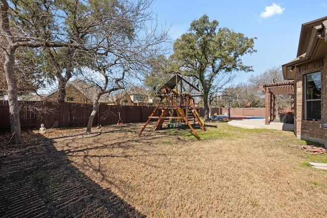 view of play area featuring a fenced backyard, a lawn, and a patio