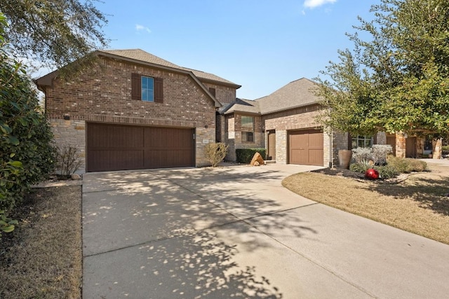 traditional-style house with concrete driveway, brick siding, and stone siding