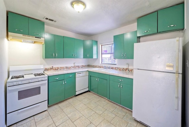 kitchen featuring tile countertops, visible vents, a sink, white appliances, and under cabinet range hood