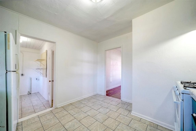 empty room with light tile patterned floors and baseboards