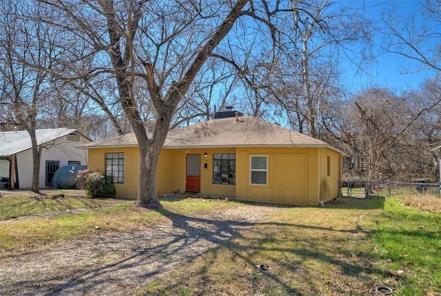 view of front of property featuring fence, a chimney, and a front lawn