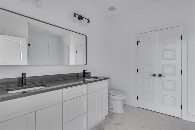 full bathroom featuring toilet, marble finish floor, visible vents, and a sink