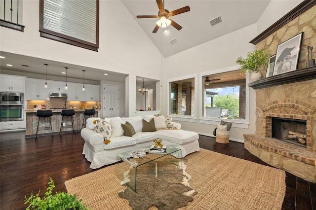 5305 Cardinal Flower Cv, Spicewood, TX 78669 - living area with a ceiling fan, dark wood finished floors, a stone fireplace, high vaulted ceiling, and recessed lighting