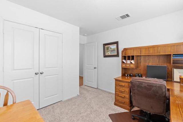 office space with visible vents, light carpet, and baseboards