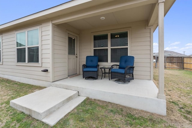 doorway to property featuring fence and a lawn