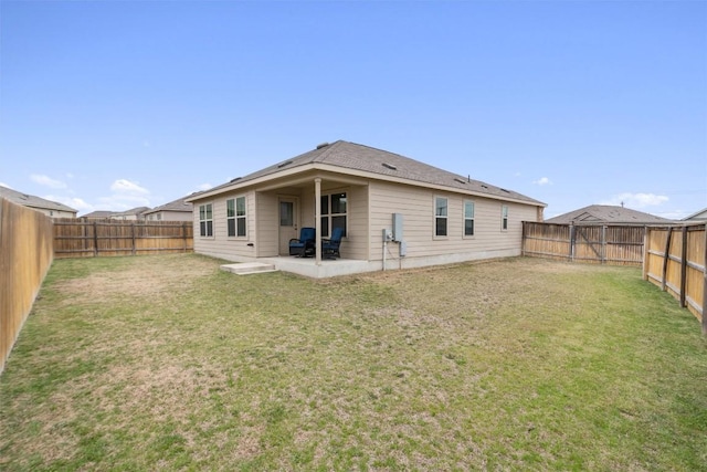 back of house with a patio, a yard, and a fenced backyard