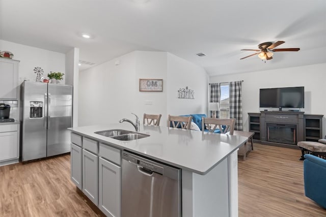 kitchen featuring visible vents, open floor plan, light countertops, stainless steel appliances, and a sink