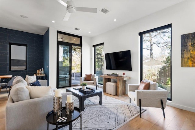 living area featuring ceiling fan, recessed lighting, a premium fireplace, wood finished floors, and visible vents